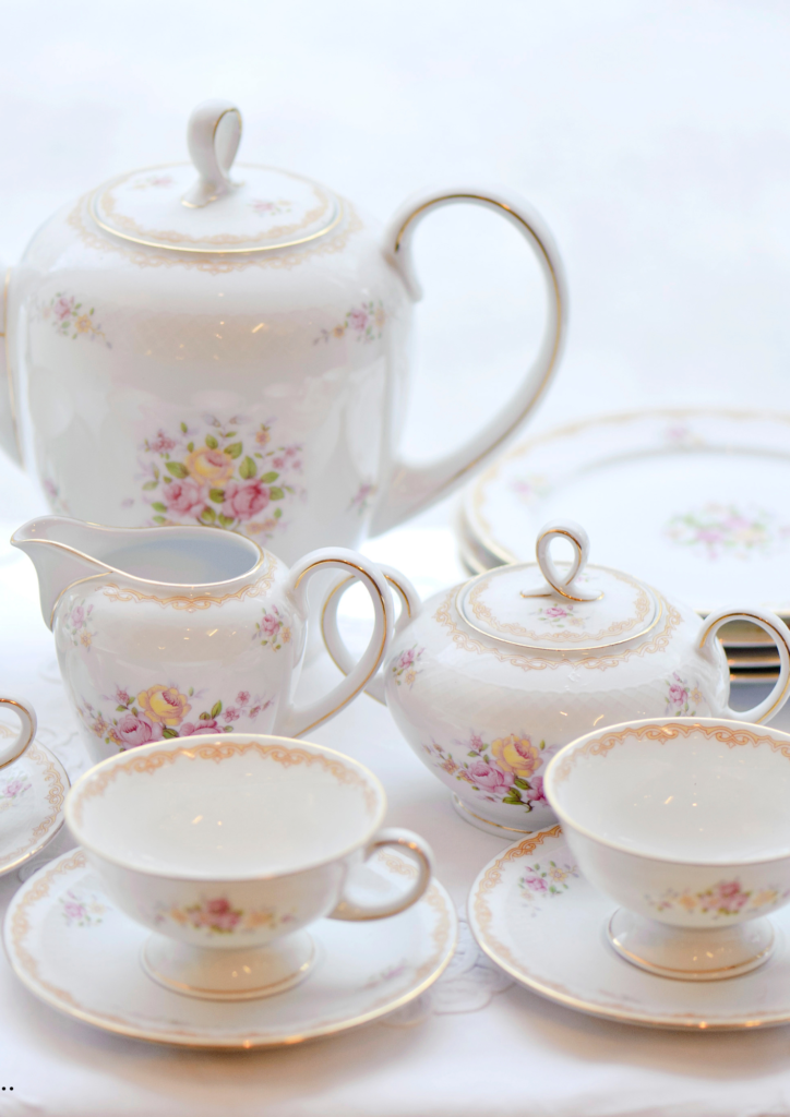 Elegant floral vintage crockery set with teacups, saucers, teapot, creamer, and sugar bowl.