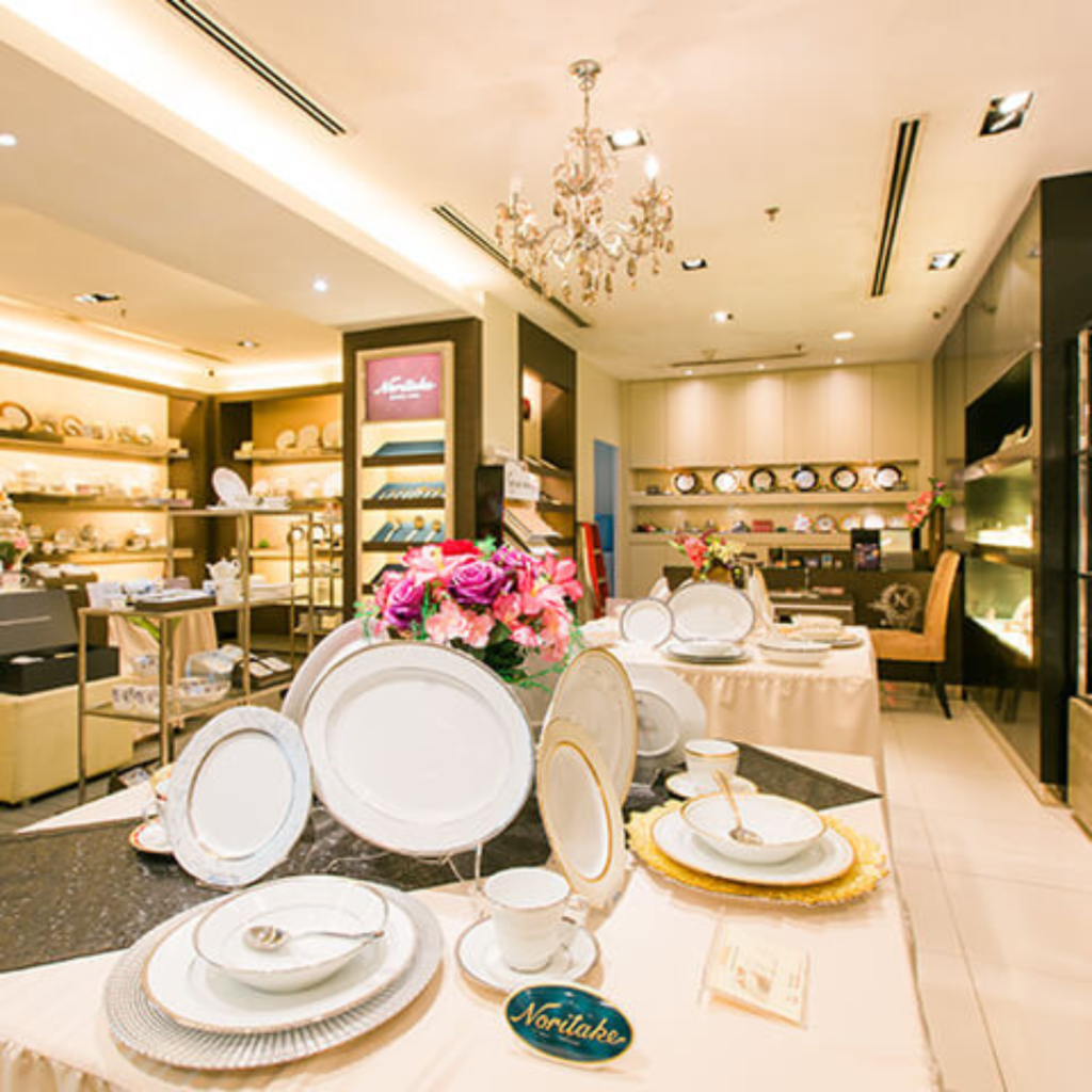 Elegant dinnerware set on display at a crockery store.